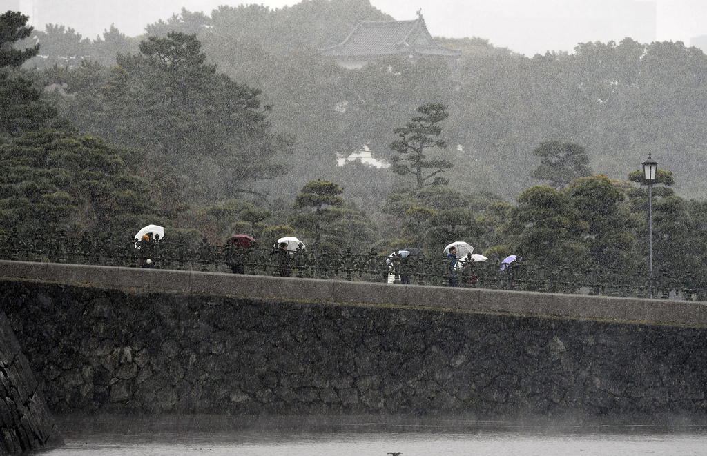  Tourists visit the surrounding gardens of the Imperial Palace during snowfall in Tokyo, Japan, 24 Nov. 2016. (EPA Photo)