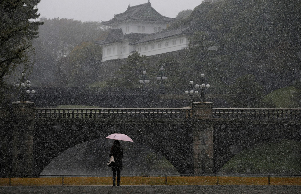 A tourist is seen during the first November snowfall in 54 years in Tokyo, at the Imperial Palace in Tokyo, Japan, Nov. 24, 2016. (REUTERS Photo)