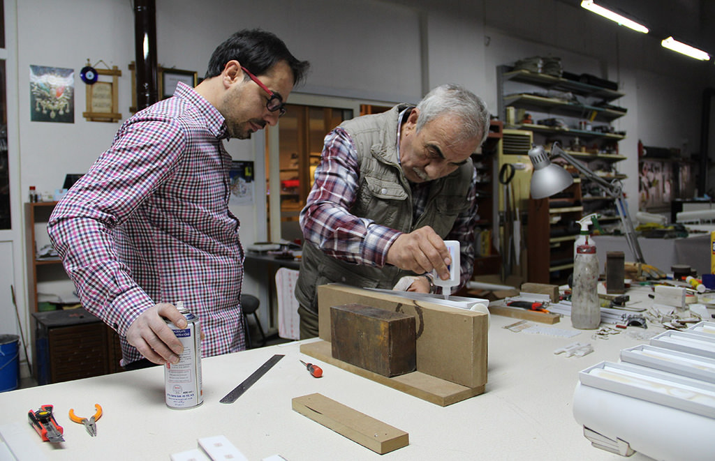 Ismail Erzurumluoğlu (right) working on a model car at his workshop in Aydın province (AA Photo)