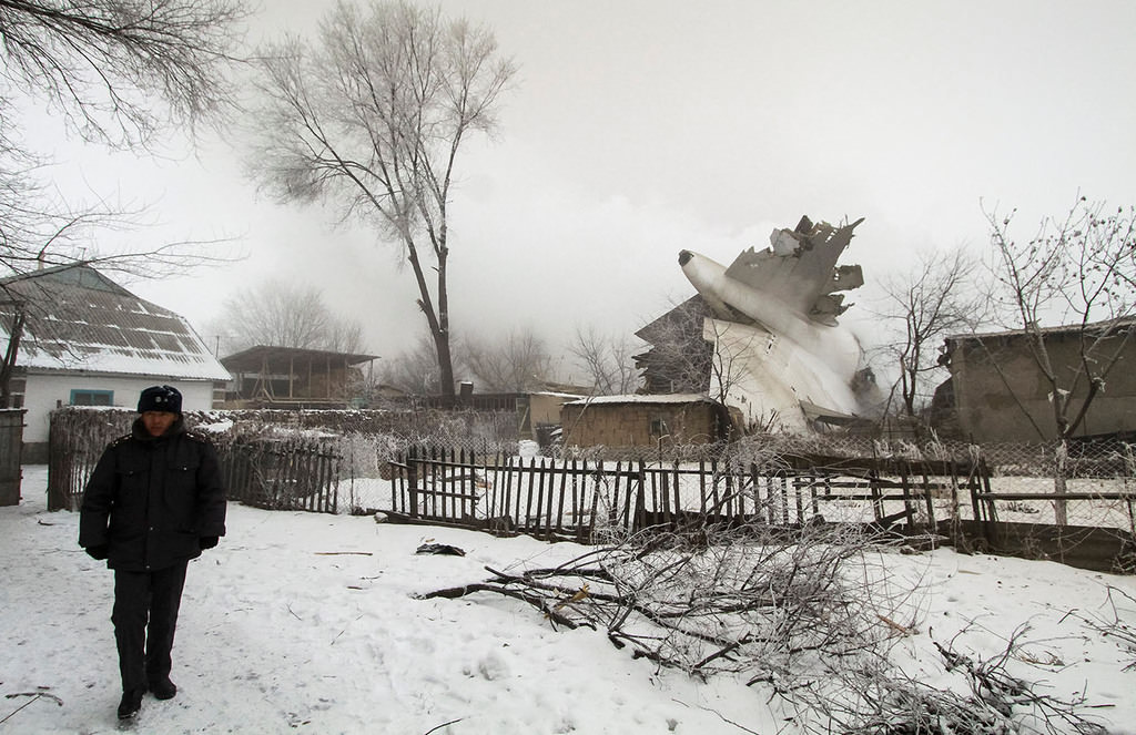 A policeman guards an area at the crash site of a Turkish cargo jet near Kyrgyzstan's Manas airport outside Bishkek, January 16, 2017. (Reuters Photo)