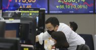 Currency traders wear face masks as they watch monitors at the foreign exchange dealing room of the KEB Hana Bank headquarters in Seoul, South Korea, Feb. 24, 2020. (AP Photo)