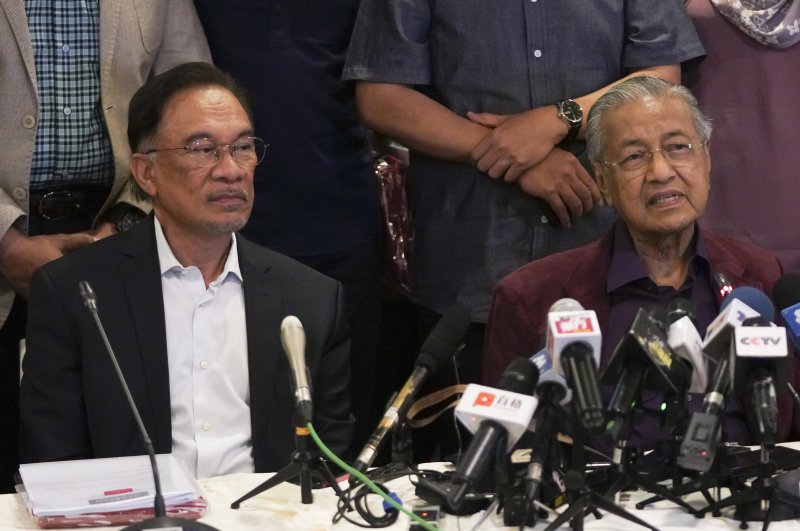 In this Feb. 22, 2020, photo, Malaysian Prime Minister Mahathir Mohamad, right, talks to media next to his successor Anwar Ibrahim in Putrajaya, Malaysia. (AP Photo)