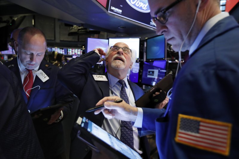 Traders Michael Urkonis, left, and Peter Tuchman, center, work on the floor of the New York Stock Exchange, Monday, Feb. 24, 2020. (AP Photo)