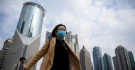 People wearing protective face masks walk on an overpass in Shanghai on February 25, 2020. (AFP Photo)