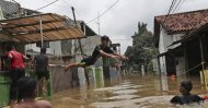 Indonesian youths play in flood water in a neighborhood in Jakarta, Indonesia, Tuesday, Feb. 25, 2020. (AP Photo)
