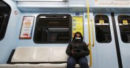 A woman wearing a face mask checks her phone in a subway in Milan, Italy, Tuesday, Feb. 25, 2020. (AP Photo)