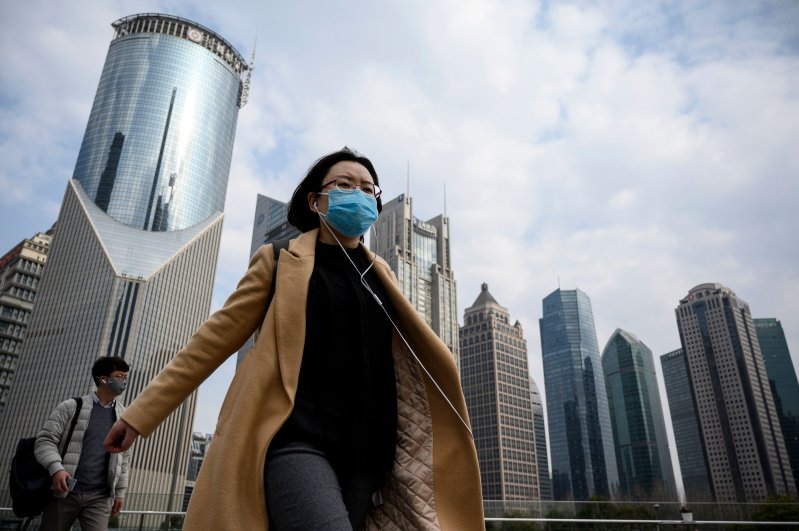 People wearing protective face masks walk on an overpass in Shanghai on February 25, 2020. (AFP Photo)