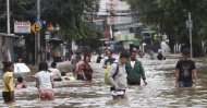 Indonesians wade through floodwater on a street in Jakarta, Feb. 25, 2020. (AP Photo)