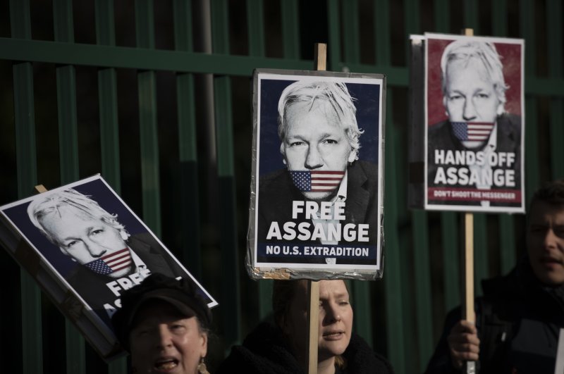 Supporters of Julian Assange hold placards outside Belmarsh Magistrates' Court in southeast London, Feb. 25, 2020. (AP Photo)