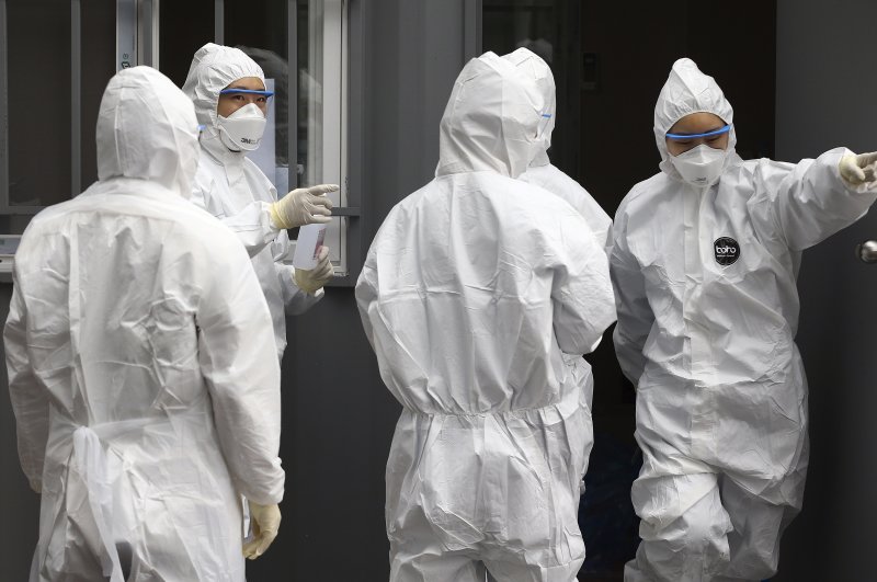 Officials wearing protective attire work to diagnose people with suspected symptoms of the new coronavirus at a hospital in Daegu, South Korea, Feb. 26, 2020. (Yonhap via AP)