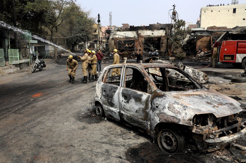 Firefighters douse a fire at Gokulpuri tire market, New Delhi, Feb. 26, 2020. (AP Photo)