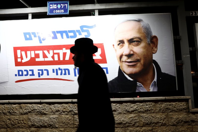 An ultra-Orthodox Jewish man walks past a Likud election campaign poster depicting Israeli Prime Minister Benjamin Netanyahu, Jerusalem, Feb. 25, 2020. (REUTERS Photo)