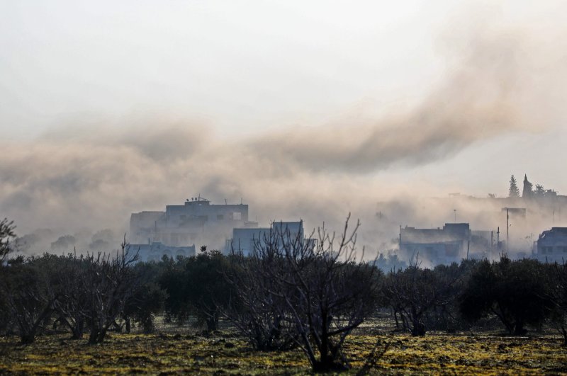 Smoke billows above buildings during an air strike by pro-regime forces on the village of Nayrab, about 14 kilometres southeast of the city of Idlib in northwestern Syria, Feb. 25, 2020. (AFP)