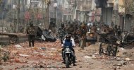 Men ride a motorcycle past security forces patrolling a street in a riot-affected area after clashes erupted over the new anti-Muslim citizenship law in New Delhi, India, Feb. 26, 2020. (REUTERS Photo)