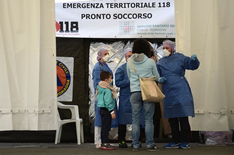A woman and a boy receive information from medical staff at a sanitary tent installed outside a hospital, Piacenza, Italy, Feb. 26, 2020. (AFP Photo)