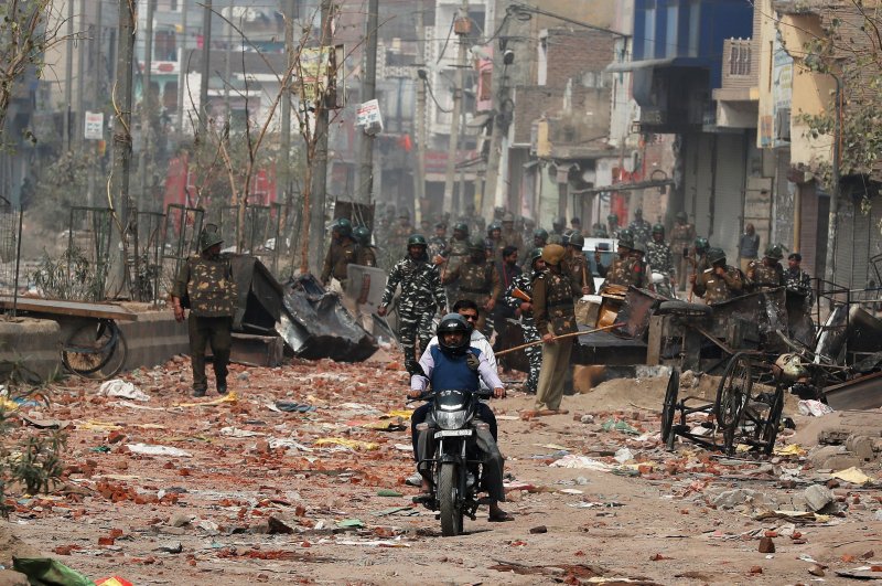 Men ride a motorcycle past security forces patrolling a street in a riot-affected area after clashes erupted over the new anti-Muslim citizenship law in New Delhi, India, Feb. 26, 2020. (REUTERS Photo)