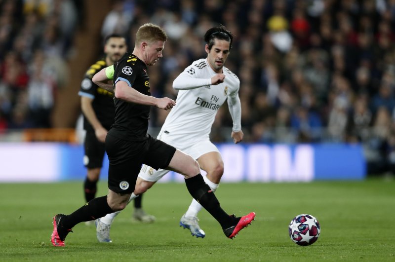 Manchester City's Kevin De Bruyne, left, duels for the ball with Real Madrid's Isco during the Champions League, round of 16, first leg soccer match between Real Madrid and Manchester City at the Santiago Bernabeu stadium in Madrid, Spain, Feb. 26, 2020. (AP Photo)