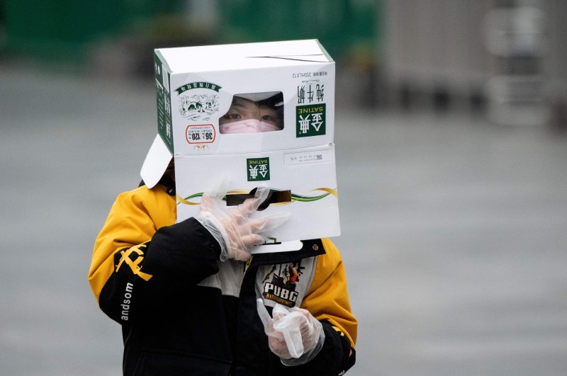 A boy wears a cardboard box on his head at the Shanghai Railway station in Shanghai on Feb. 13, 2020. (AFP Photo)