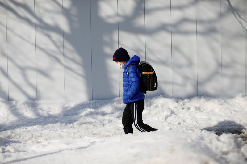 An elementary school student wearing a mask walks on a snow-covered street, Sapporo, Japan, Feb. 26, 2020.  (Reuters Photo)