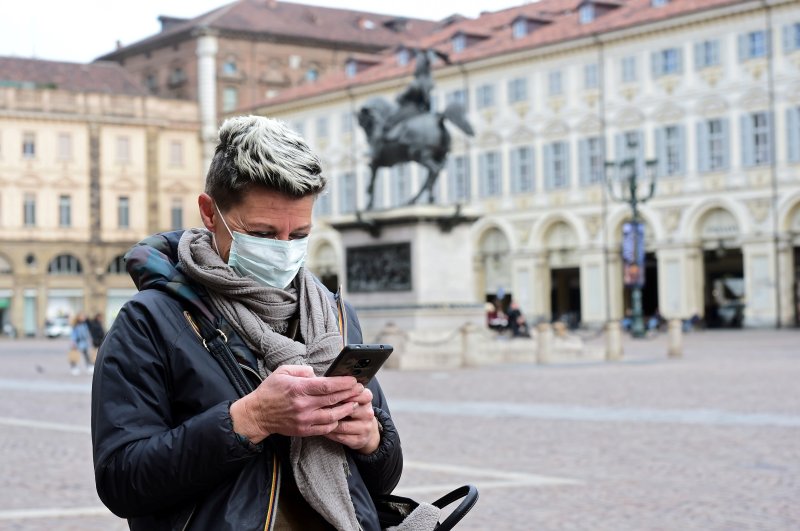 A woman wearing a protective mask uses her mobile phone, Turin, Feb. 27, 2020. (REUTERS Photo)