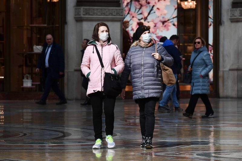 Tourist wearing protective masks walk in Galleria Vittorio Emanuele II, Milan, Feb. 28, 2020. (AFP Photo)