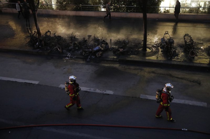 Firefighters walk past charred vehicles after a fire near the Gare de Lyon train station Friday, Feb. 28, 2020 in Paris. (AP Photo)