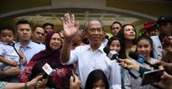 Malaysia's former interior minister Muhyiddin Yassin (C) and his family wave to the press shows outside his home in Kuala Lumpur on Feb. 29, 2020. (AFP Photo)