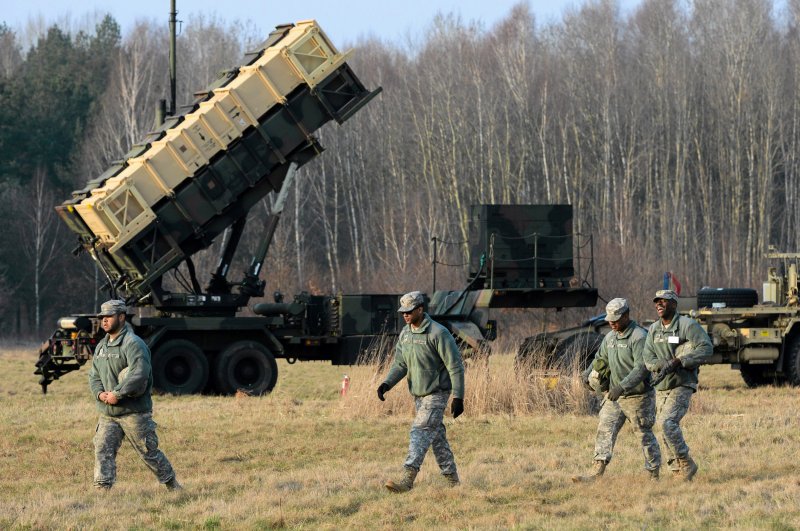 U.S soldiers walk next to a Patriot missile defense battery during join exercises at the military grouds in Sochaczew, Poland, March 21, 2015. (Reuters Photo)