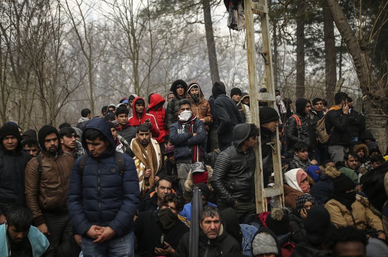 Migrants gather between Pazarkule border gate, Edirne, Turkey, and Kastanies border gate, Evros region, as they try to enter Greece, on Saturday, Feb. 29, 2020. (AP Photo)