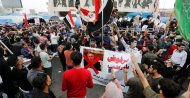 Iraqi demonstrators carry a poster depicting Iraqi Prime Minister Mohammed Tawfiq Allawi, to express their rejection of him, Baghdad, March 1, 2020. (Reuters Photo)