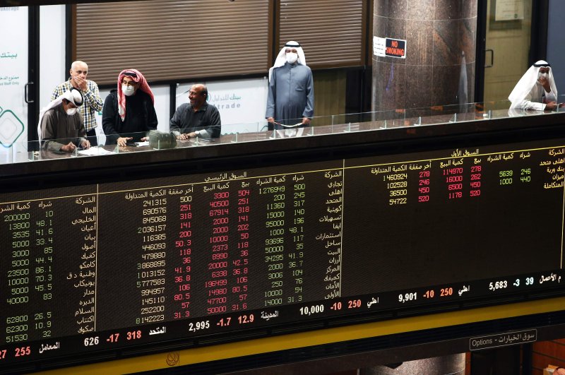Kuwaiti traders wearing protective masks follow the market at the Boursa Kuwait stock exchange in Kuwait City, March 1, 2020. (AFP Photo)