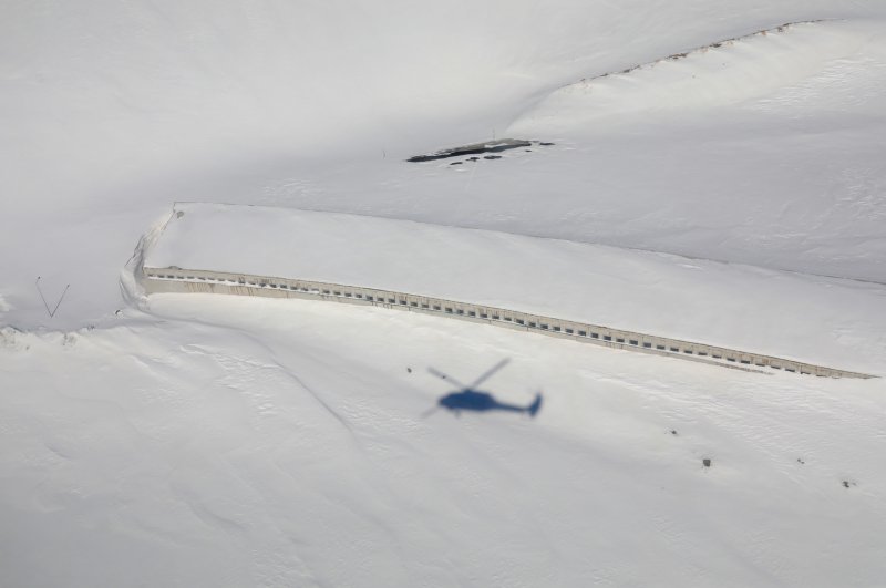 A helicopter flies over the snow-covered bridge, Van, Mar. 1, 2020. (AA Photo)