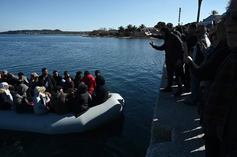 Migrants are seen on an inflatable boat as local residents prevent them from disembarking in Lesbos island, on March 1, 2020. (AFP Photo)