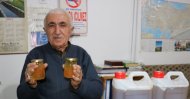 Mehmet Kasım Alageyik poses with jars of what he claims contain the solution to the world's coronavirus problem, Van, March 2, 2020. (İHA Photo)
