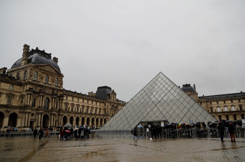 People wait in front of the Louvre Pyramide in Paris on March 1, 2020 (AFP Photo)
