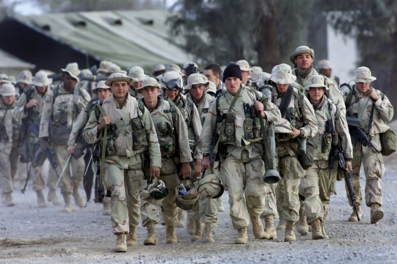 U.S. Marines in full gear prepare to leave the U.S. military compound at Kandahar International Airport for a mission to an undisclosed location, Afghanistan, Dec. 31, 2001. (AP Photo)
