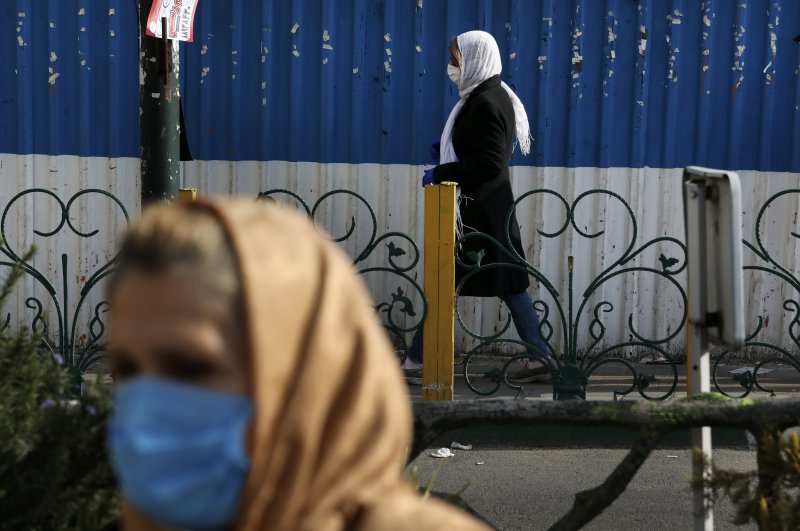 Pedestrians wearing face masks walk on the sidewalks in northern Tehran, Iran, Sunday, March 1, 2020. (AP Photo)