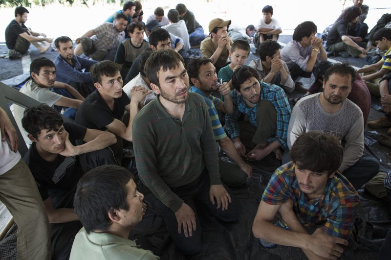 Suspected Uighurs from China's troubled far-western region of Xinjiang, sit inside a temporary shelter after they were detained at the immigration regional headquarters near the Thailand-Malaysia border in Hat Yai, Songkla March 14, 2014. (Reuters File Photo)