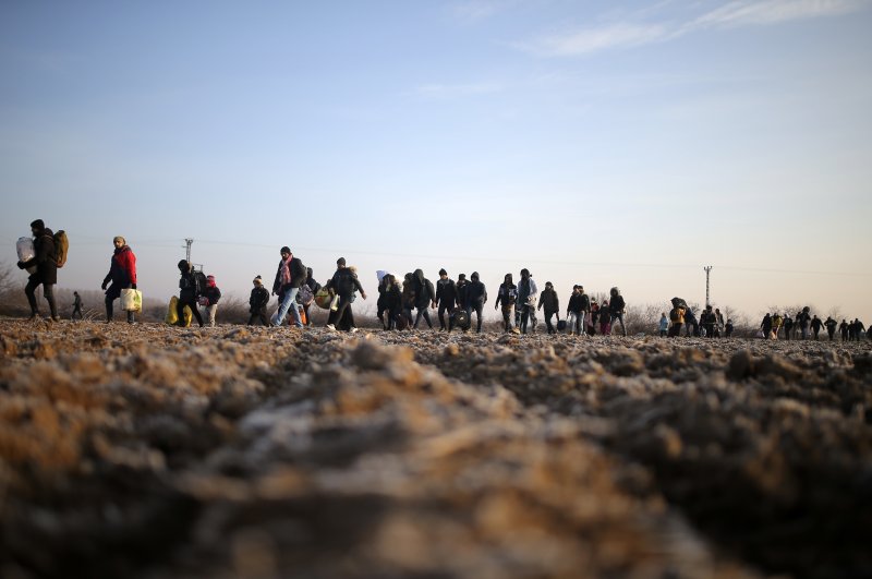 Migrants walk to reach the Pazarakule border gate at the Turkish-Greek border in Edirne, Turkey, March 1, 2020. (AP Photo)