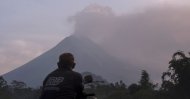 A man watches as Mount Merapi spews volcanic material into the air in Sleman, Indonesia, Tuesday, March 3, 2020. (AP Photo)