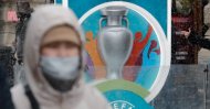 A person wearing a protective face mask walks past the Euro 2020 countdown clock in Saint Petersburg, Russia, March 1, 2020. (Reuters Photo)