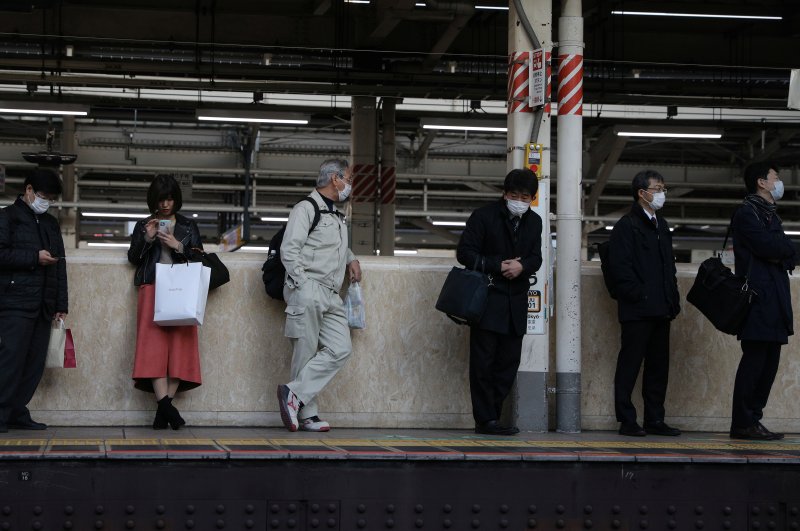 People wearing protective face masks wait for their train at the Tokyo station, Tokyo, March 3, 2020. (REUTERS Photo)