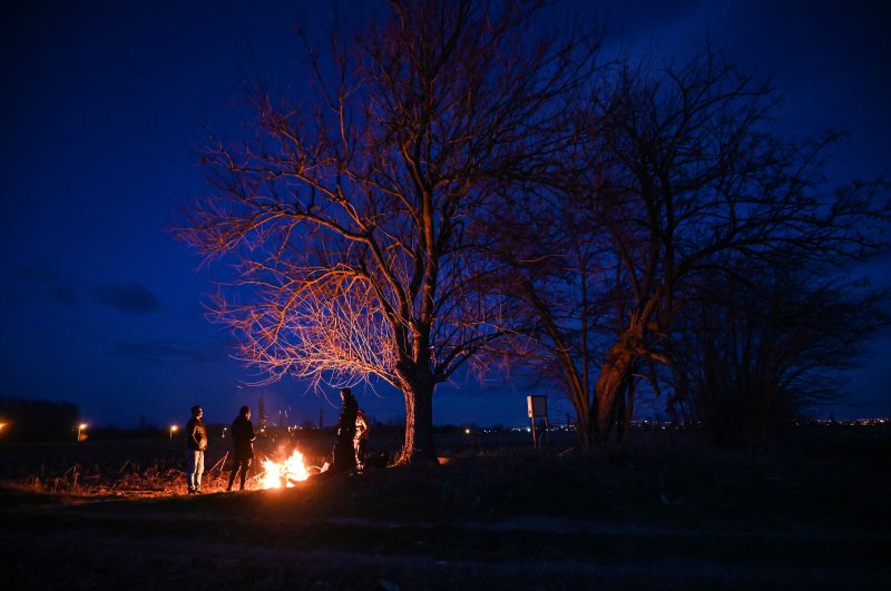 Migrants light a fire while camping next the Greek border, along the Turkey-Greece border near Pazarkule, Feb. 28, 2020. (AFP Photo)