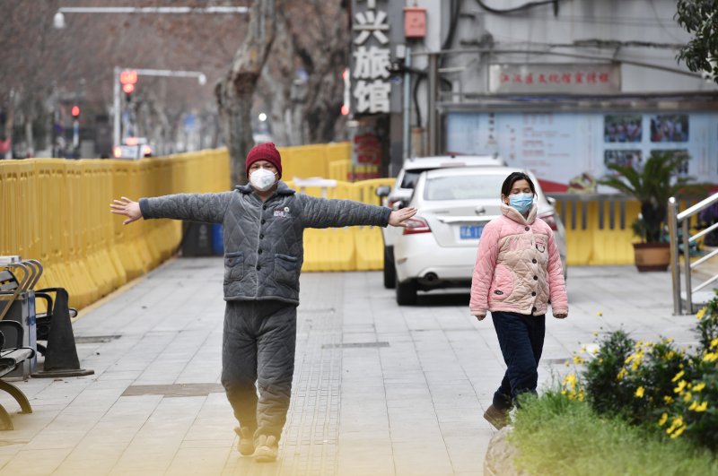 A man wearing a face mask exercises near barriers separating the road from the roadside, Wuhan, March 3, 2020. (REUTERS Photo)