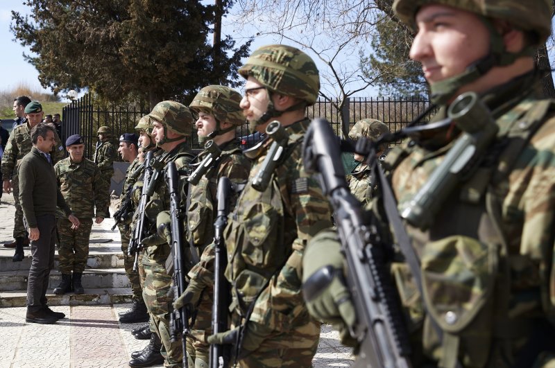 Greek Prime Minister Kyriakos Mitsotakis (L) reviews Greek soldiers' guard at the Kipoi border gate, Evros region, at the Greek-Turkish border on Tuesday, March 3, 2020. (Greek Prime Minister's Office via AP)