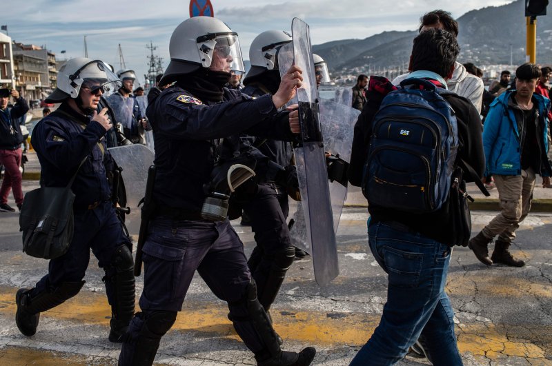 Migrants and refugees scuffle with riot police on the Greek Aegean island of Lesbos, on March 3, 2020, amid a migration surge from neighboring Turkey after it opened its borders to thousands of refugees trying to reach Europe. (AFP Photo)