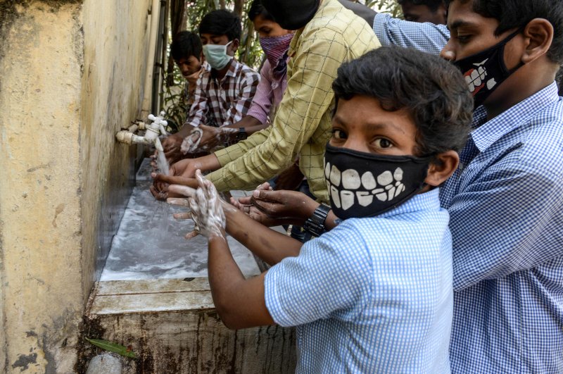 Students wearing facemasks wash their hands before attending a class at a governement-run high school in Secunderabad, the twin city of Hyderabad, on March 4, 2020, as part of health measures taken against the COVID-19 coronavirus outbreak. (AFP Photo)