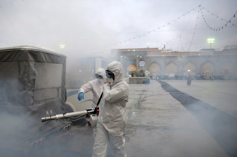 Members of a medical team spray disinfectant to sanitize an outdoor area of Imam Reza's holy shrine, Mashhad, Feb. 27, 2020. (REUTERS Photo)