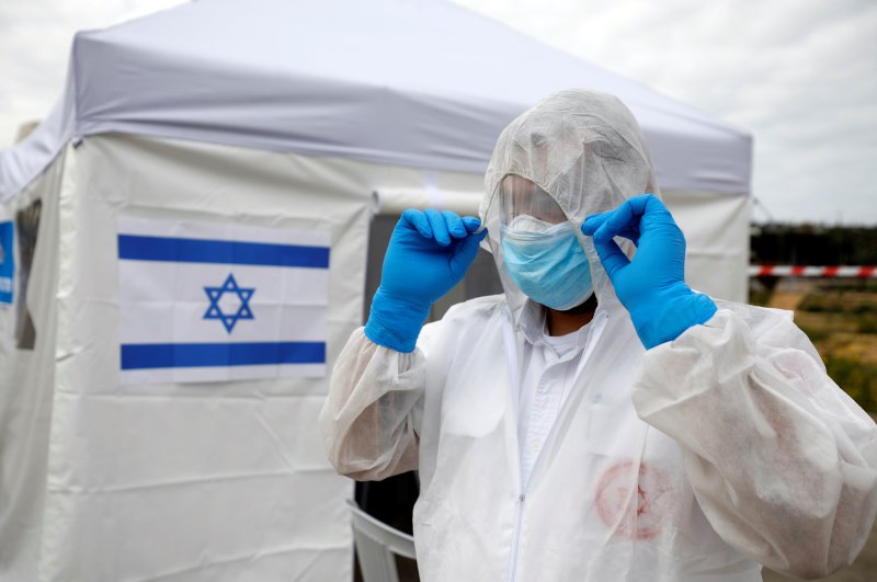 A paramedic adjusts his protective suit as he prepares outside a special polling station set up by Israel's election committee so Israelis under home-quarantine, such as those who have recently traveled back to Israel from coronavirus hot spots can vote in Israel's national election, in Ashkelon, Israel March 2, 2020. (Reuters Photo)