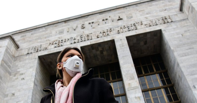 A woman wearing a respiratory mask exits from the Palace of Justice in Milan, on March 5, 2020. (AFP Photo)